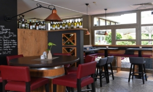 Tageslicht-Bar mit roten Sesseln und Weinkühler