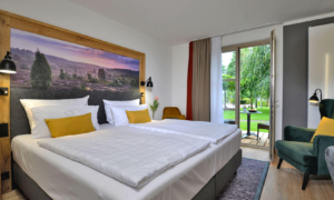 Doppelzimmer_Komfort_Plus Doppelbett mit Landschaftsbild und Zugang zur Terrasse
