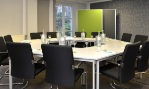 Landhotel-Schnuck-1118-082_a84baf98cf Konferenzraum mit grünem Akzent und runden Tischen