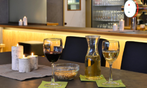 Getränkekaraffe und Gläser an Bartisch mit Thekenblick