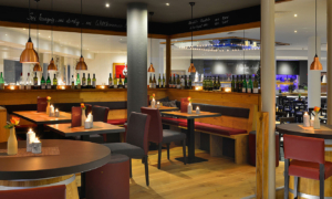 Warme Baratmosphäre mit roten Stühlen und Holztischen