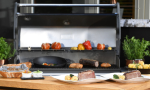 Grillplatte mit Fleisch und Gemüse auf Holztheke