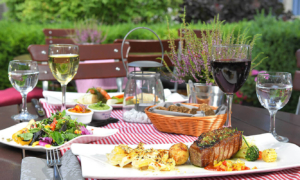 Zwei gedeckte Teller auf kariertem Tischtuch im Garten