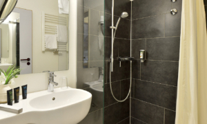 Landhotel-Schnuck-EZ-Bad-0617_208_cc6d4773f4 Dusche mit dunkler Wandverkleidung und Duschvorhang