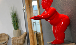 Rote Figur in Empfangsbereich mit Sessel und Pflanze