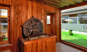 Holzpavillon mit Wasserrad im Spa-Außenbereich