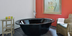 Schwarze Wellnessbadewanne mit Handtuch und Deko