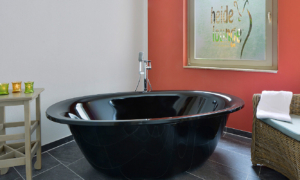 Schwarze Wellnessbadewanne mit Handtuch und Deko