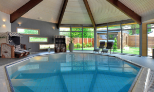 Innenpool mit Holzdecke und Panoramafenstern