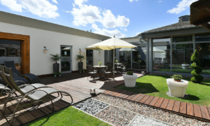 Landhotel-Schnuck-Heide-Lounge-0619-171_5596c157d5 Spa-Terrasse mit Liegestühlen, Sonnenschirmen und Rasen