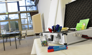 Seminarraum mit Fensterfront und Flipchart, Moderationskoffer im Vordergrund