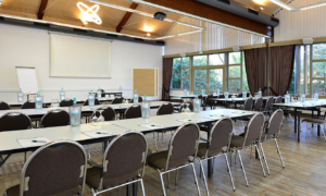 Großer Seminarraum mit Stuhlreihen und Leinwand