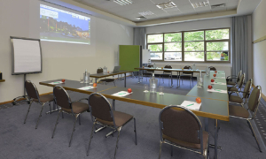 Seminarraum mit U-Bestuhlung, Leinwand und Tageslicht