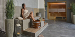 Frau entspannt im Wellnessbereich mit Sauna und Fußbad