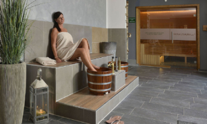 Frau entspannt im Wellnessbereich mit Sauna und Fußbad