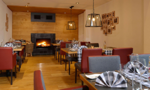 Landhotel-Schnuck_0722_030_Slider_9c6e53c106 Restaurant mit Kamin, roten Polsterstühlen und Holzdecke