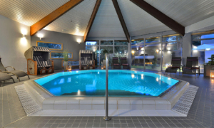 Innenpool mit Liegen und Holzdecke