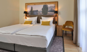 Suite_4_60f79bd790 Hotelzimmer mit Doppelbett und Landschaftsbild über dem Bett
