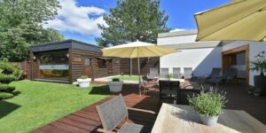 Sonnige Terrasse mit Sitzplätzen, Sonnenschirmen und Holzboden