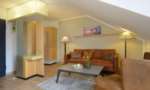 Landhotel_Schnuck-Heideland-Suite-0822_24 Dachgeschosszimmer mit Sitzecke, Sofa und Tisch