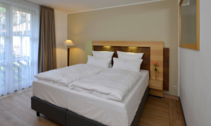 Landhotel_Schnuck-Heideland-Suite-0822_46 Doppelbett mit zwei Kopfkissen und Tageslicht