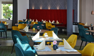 Farbige Sitzgruppen und gedeckte Tische im Hotelrestaurant