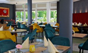 Landhotel-Schnuck-Findlinger-0524_136 Modernes Restaurant mit bunten Polsterstühlen und weiß gedeckten Tischen