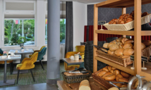 Brotregal mit Brötchen und Baguette im Frühstücksraum