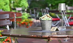 Rustikaler Holztisch mit Blumendeko im Garten des Hotels