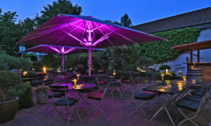 Terrasse am Abend mit lila Beleuchtung und gemütlichen Sitzgruppen